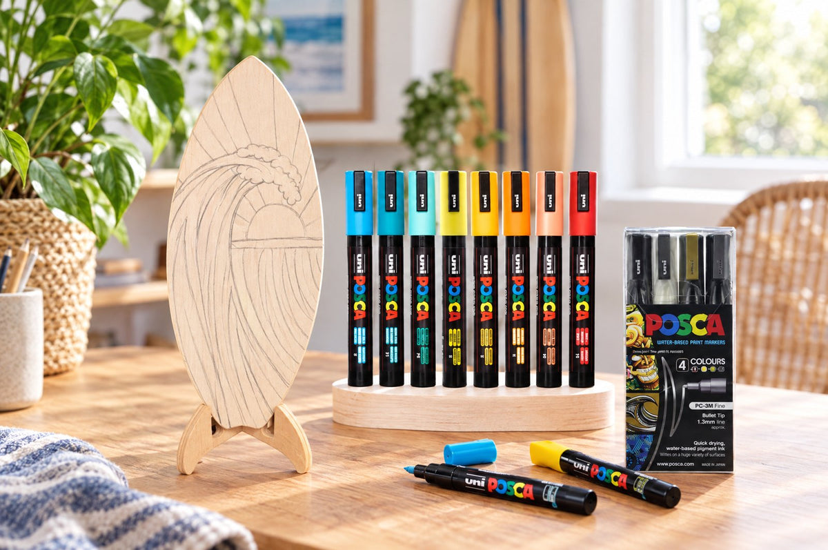 POSCA markers decorating a wooden surfboard on its stand
