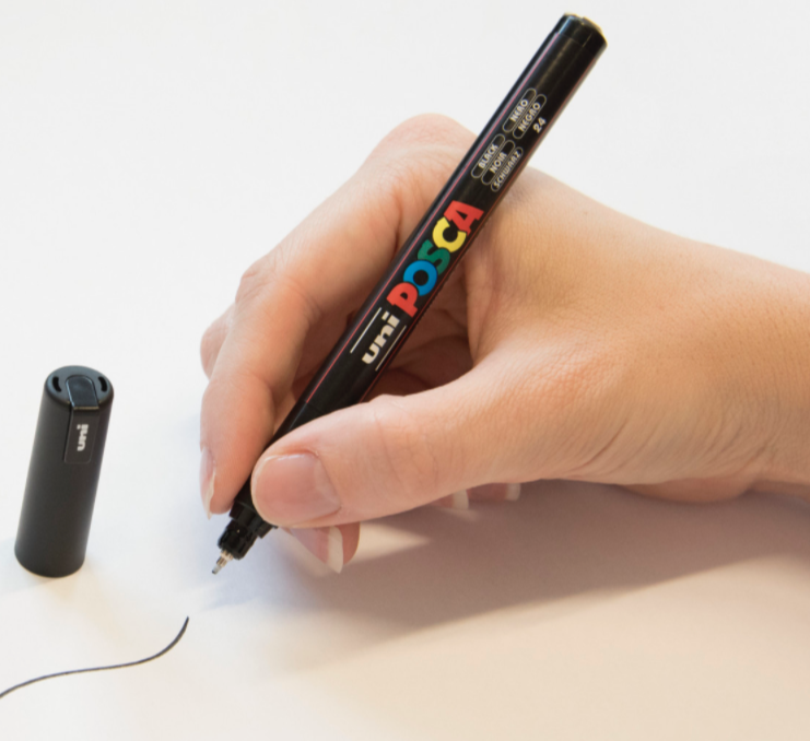 Artist drawing fine detail on paper with a POSCA PC-1MR marker