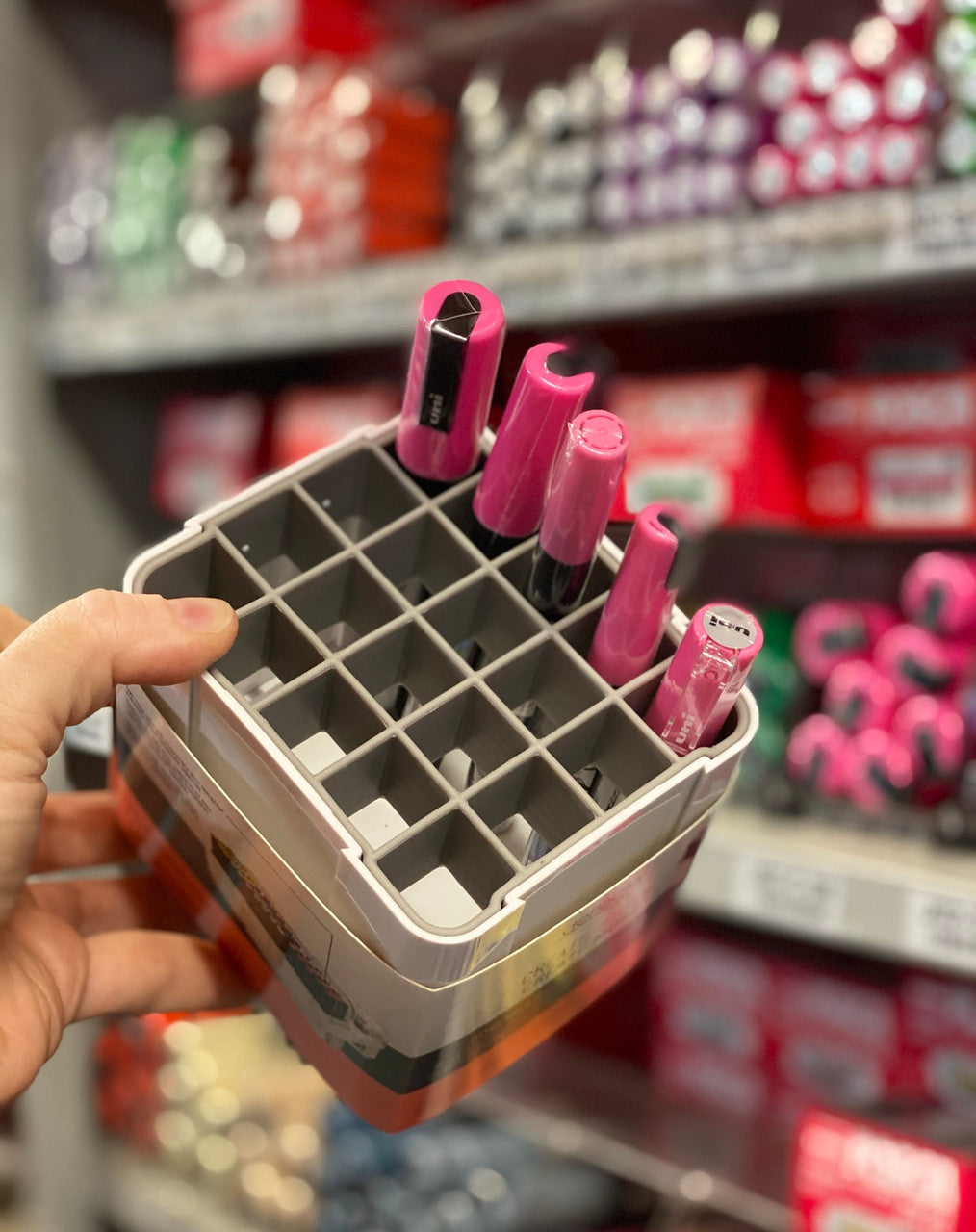 Deflecto interlocking marker organiser held in hand with POSCA markers stored