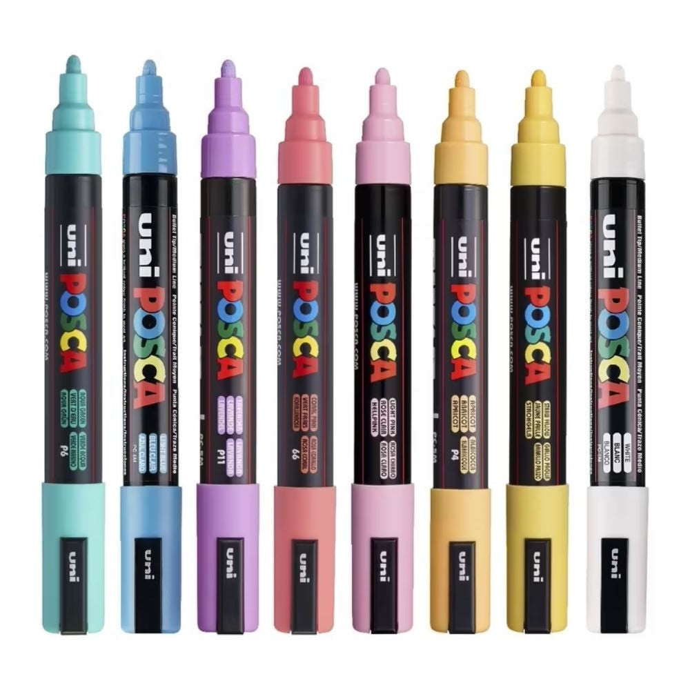 Eight POSCA PC-3M pastel markers standing uncapped with bullet tips showing