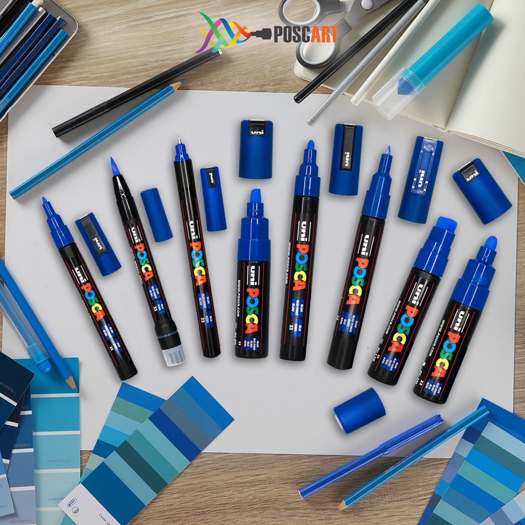 POSCA blue 8 tip set laid out with a notebook and pencil case