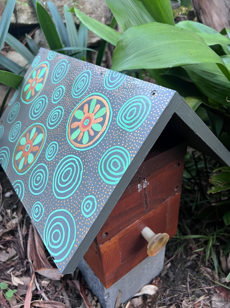 Beehive roof painted with turquoise circles and orange flowers using POSCA