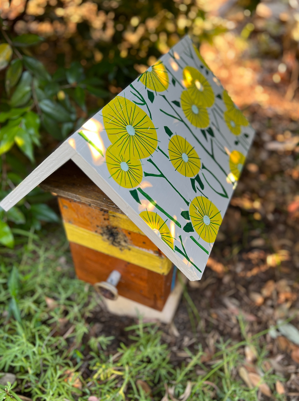 Beehive roof painted with yellow flowers using POSCA markers