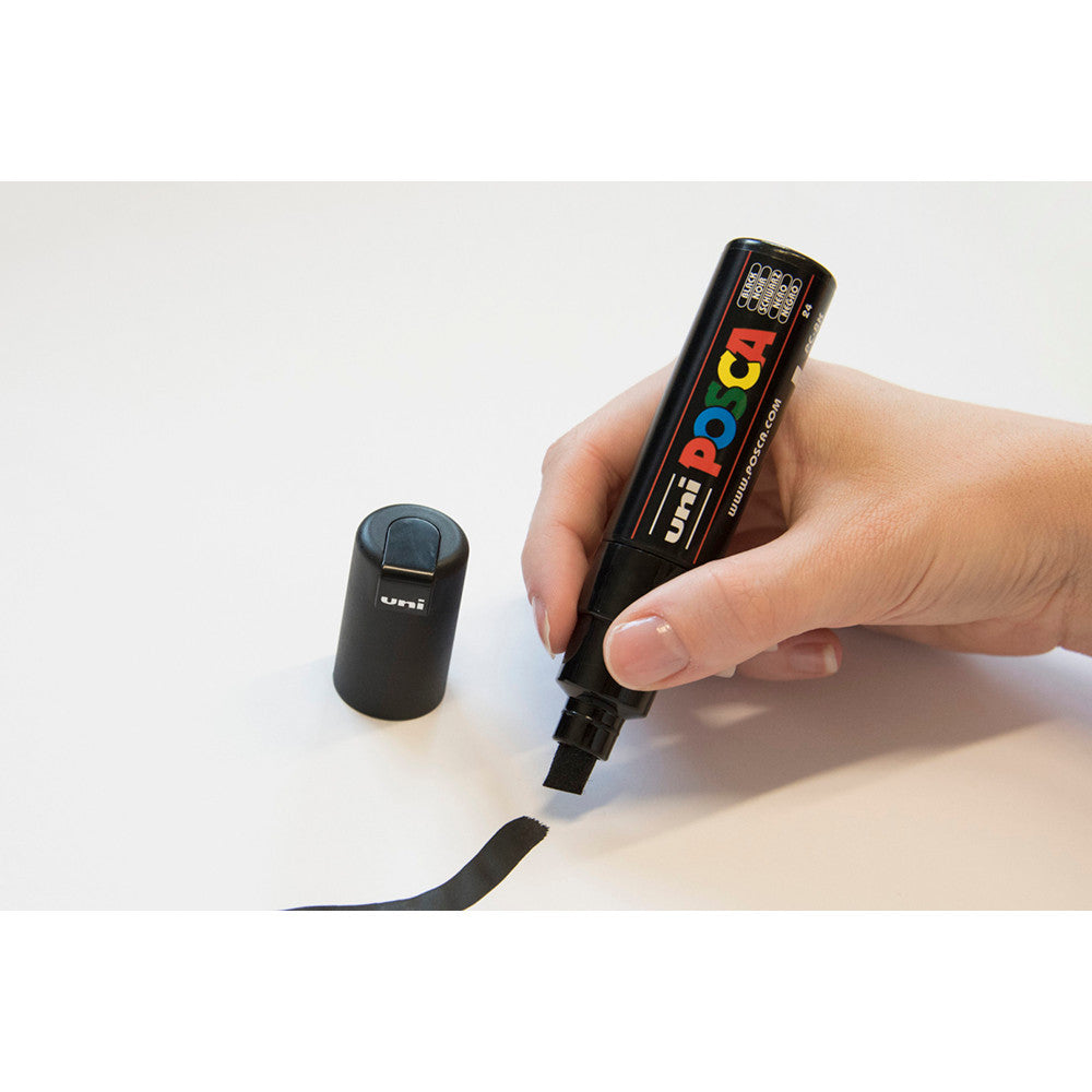 Hand drawing a wide stroke on white paper with a POSCA PC-8K chisel tip marker