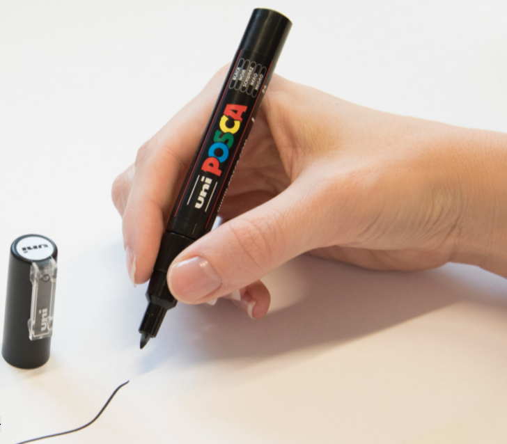 Artist drawing fine linework with a POSCA PC-1M marker